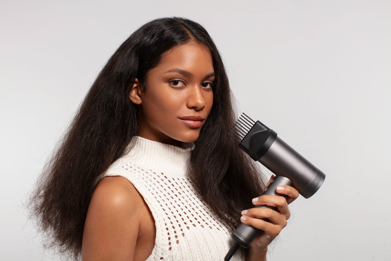 a woman holding a hair dryer in her hand